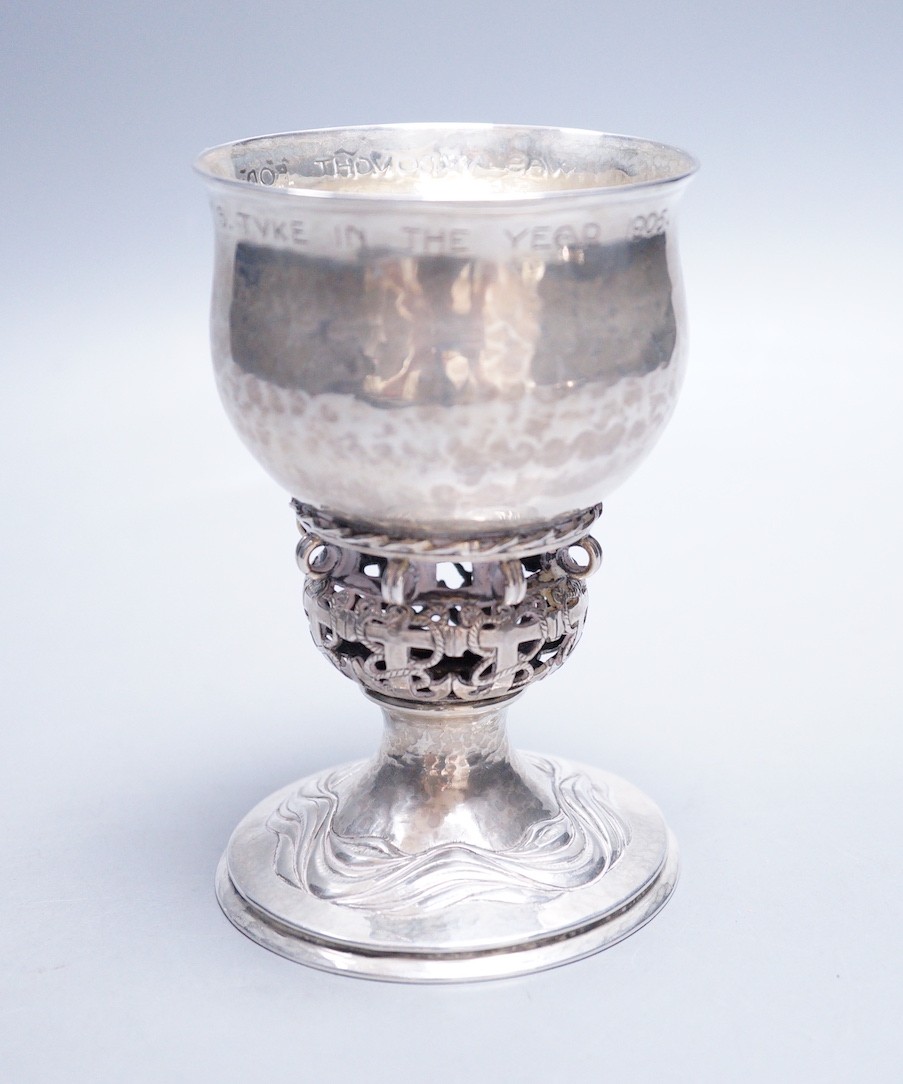 An Edwardian Arts & Crafts planished silver chalice, by Ramsden & Carr, inscribed ' I was wrought for Henry S. Tuke in the year 1905', with pierced stem, on circular foot, London, 1905, 12.3cm, 181 grams, the base inscri
